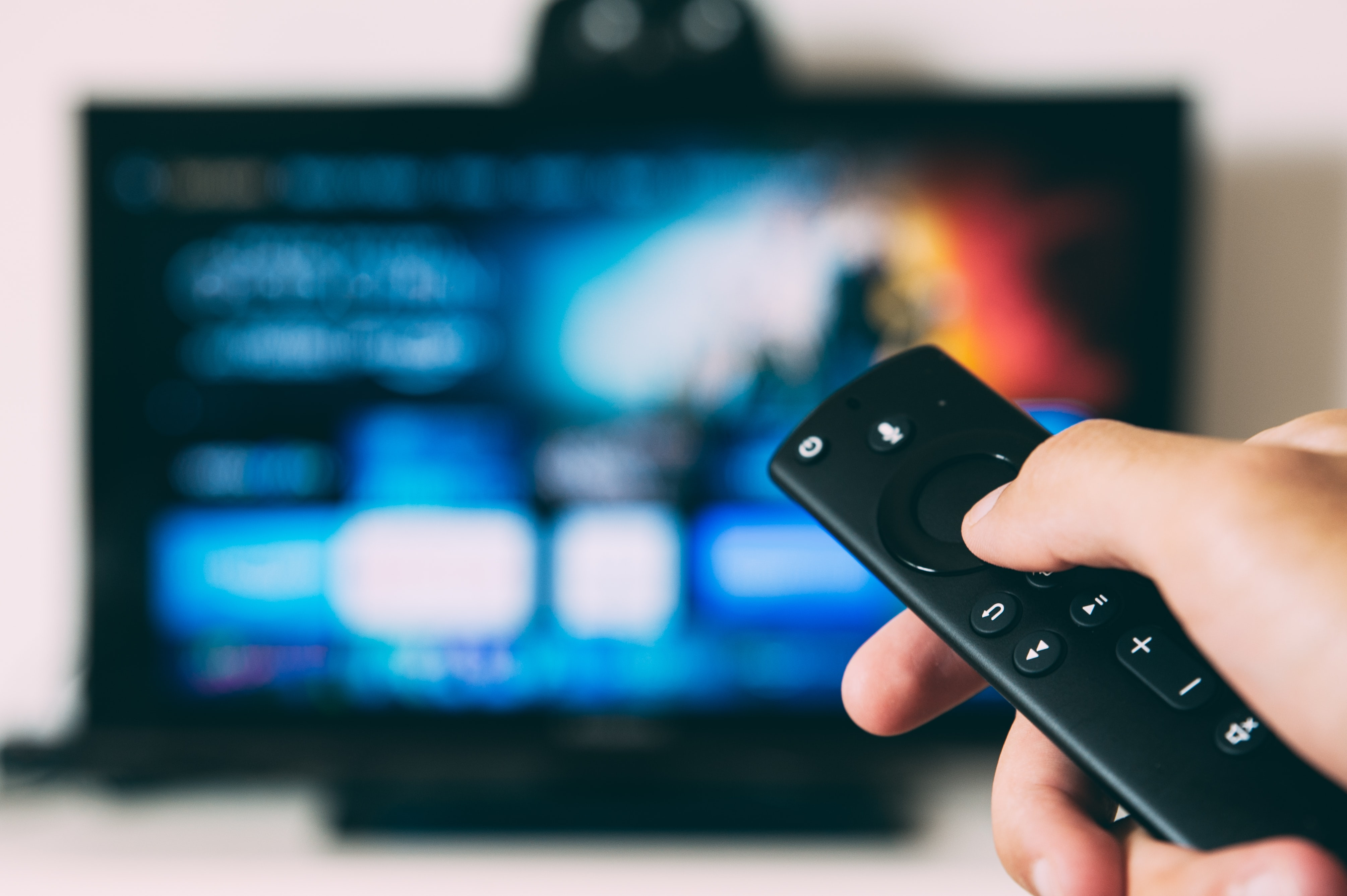 Someone points a remote control at a TV. Någon riktar en fjärrkontroll mot en TV.