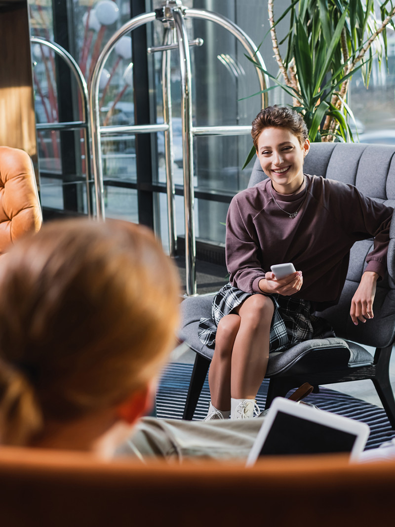 Women sitting in a lobby talking. Kvinnor som sitter i en lobby och pratar.