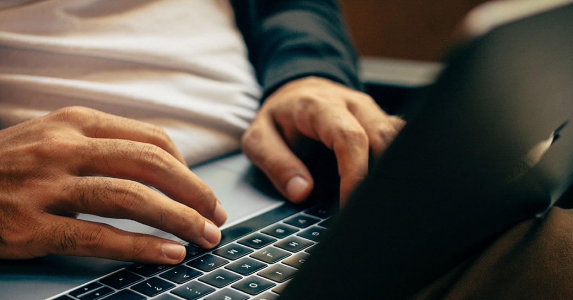 Man holding a laptop on his lap. Man som håller en laptop i knät.