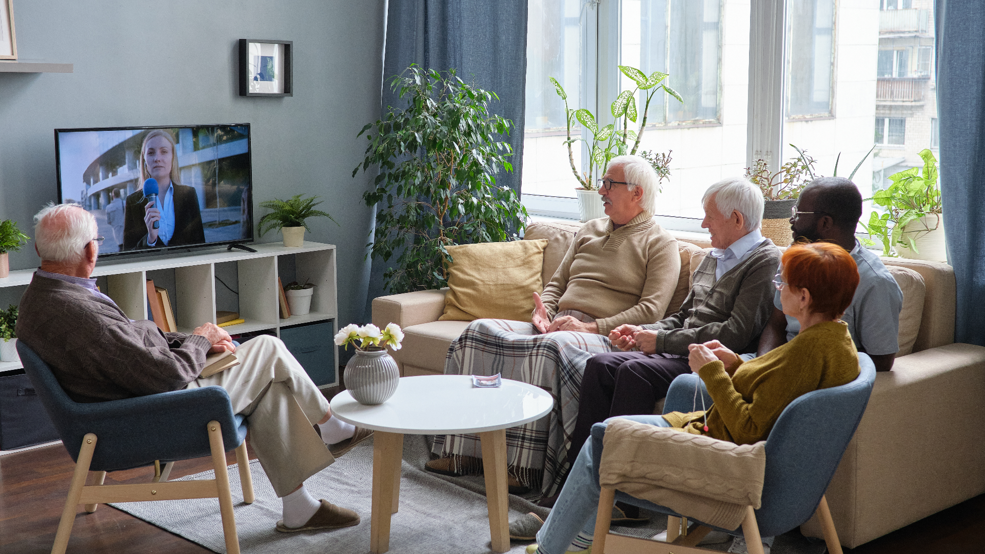 Äldre personer på ett ålderdomshem som ser på tv.